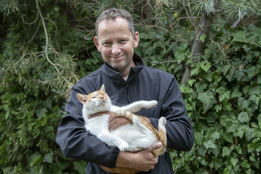 Sławek Adamczak, twórca Photomappii, z kotem na rękach